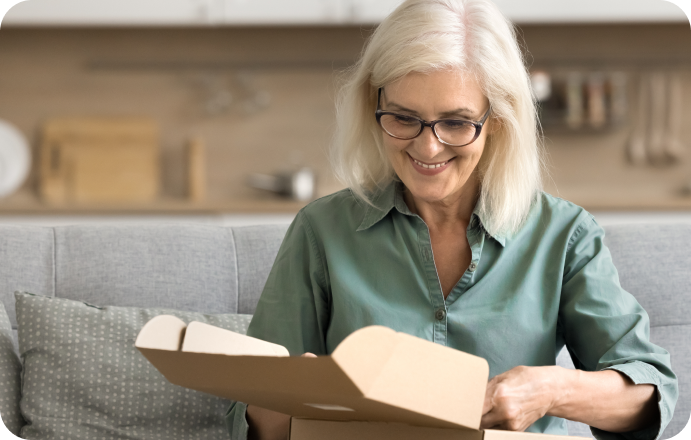 Woman opening package on her couch